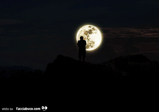 Uomo che fissa la luna dalla cima della montagna