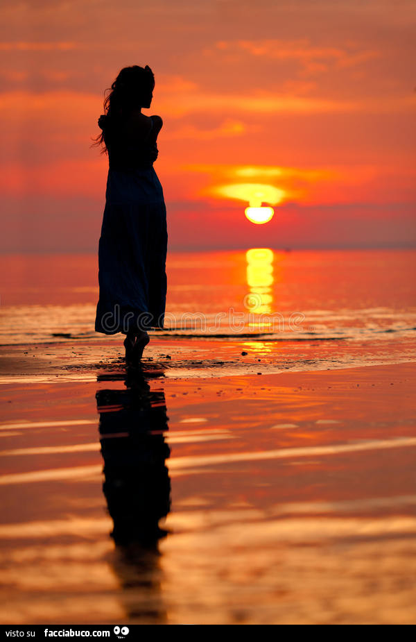 Donna in riva al mare al tramonto